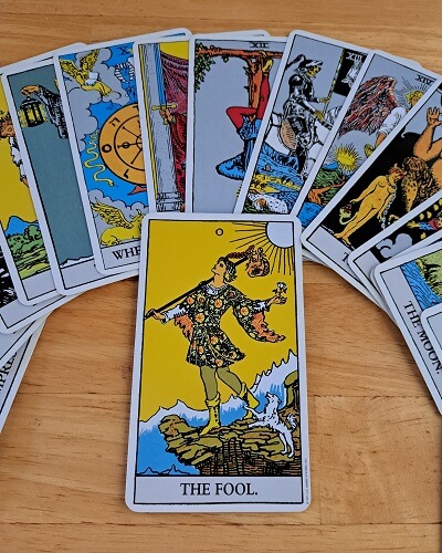 The Fool with Assorted Major Arcana in the background start the journey to learn tarot card meanings