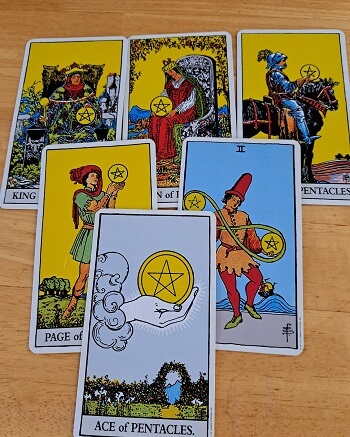 Tarot card meanings for the suit of pentacles. Image shows several cards